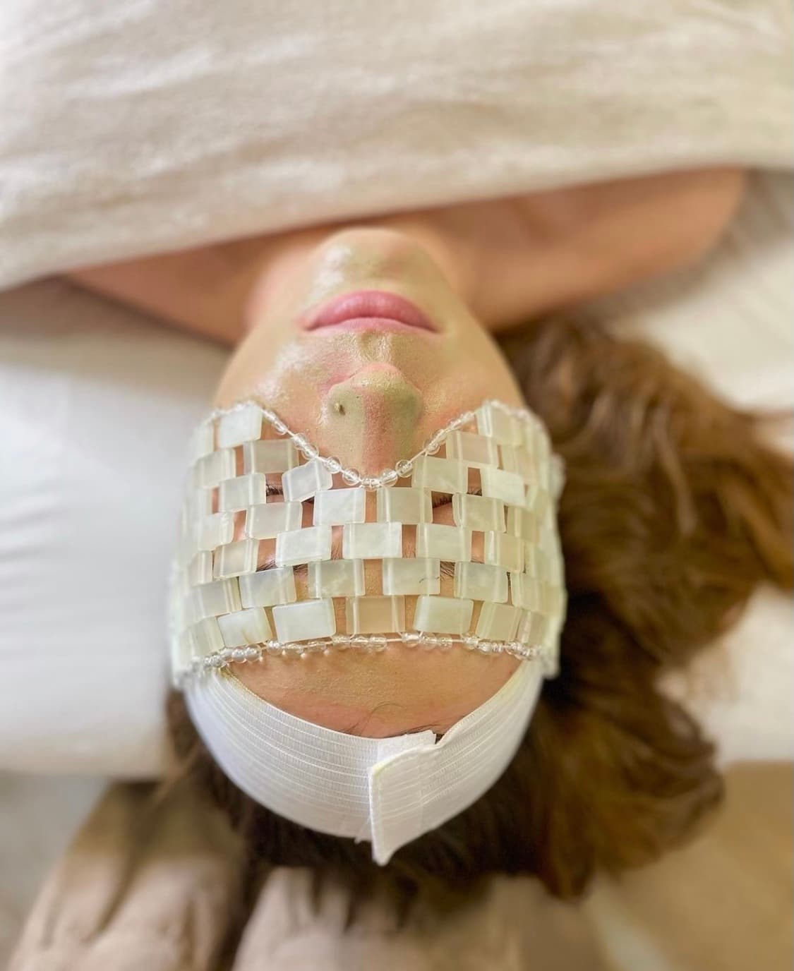 Woman with a jelly mask on during a facial treatment